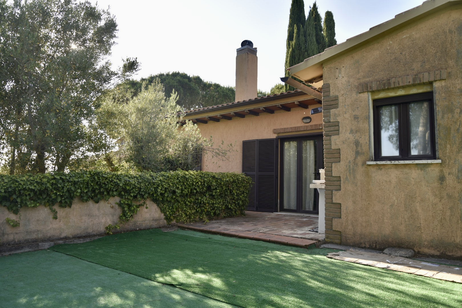 Farmhouse exterior with olive trees and garden at Madrechiesa